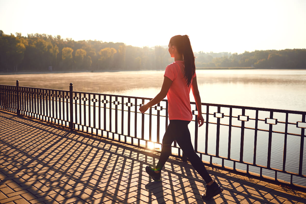 A woman walking across a bridge. Forming new habits can help you achieve your New Year's resolutions.