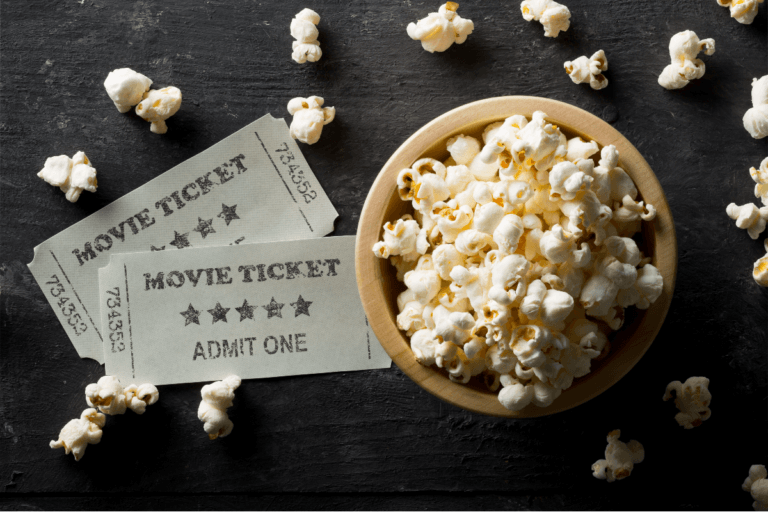 A bowl of popcorn and movie tickets