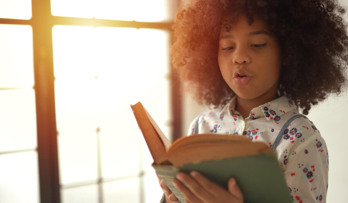 An African Canadian girl reading a book.