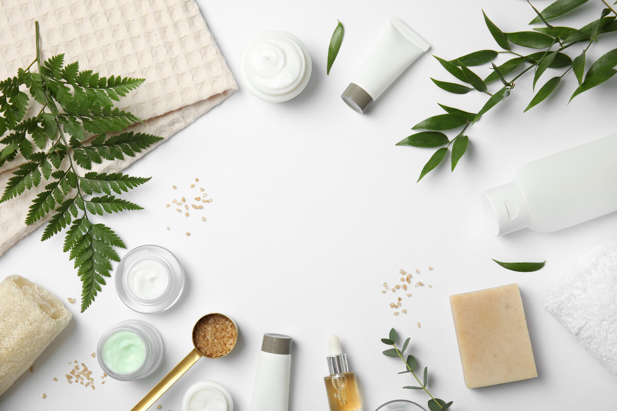 Clean beauty products in white containers over a white background. Using clean beauty products is another way to have a sustainable morning routine. 