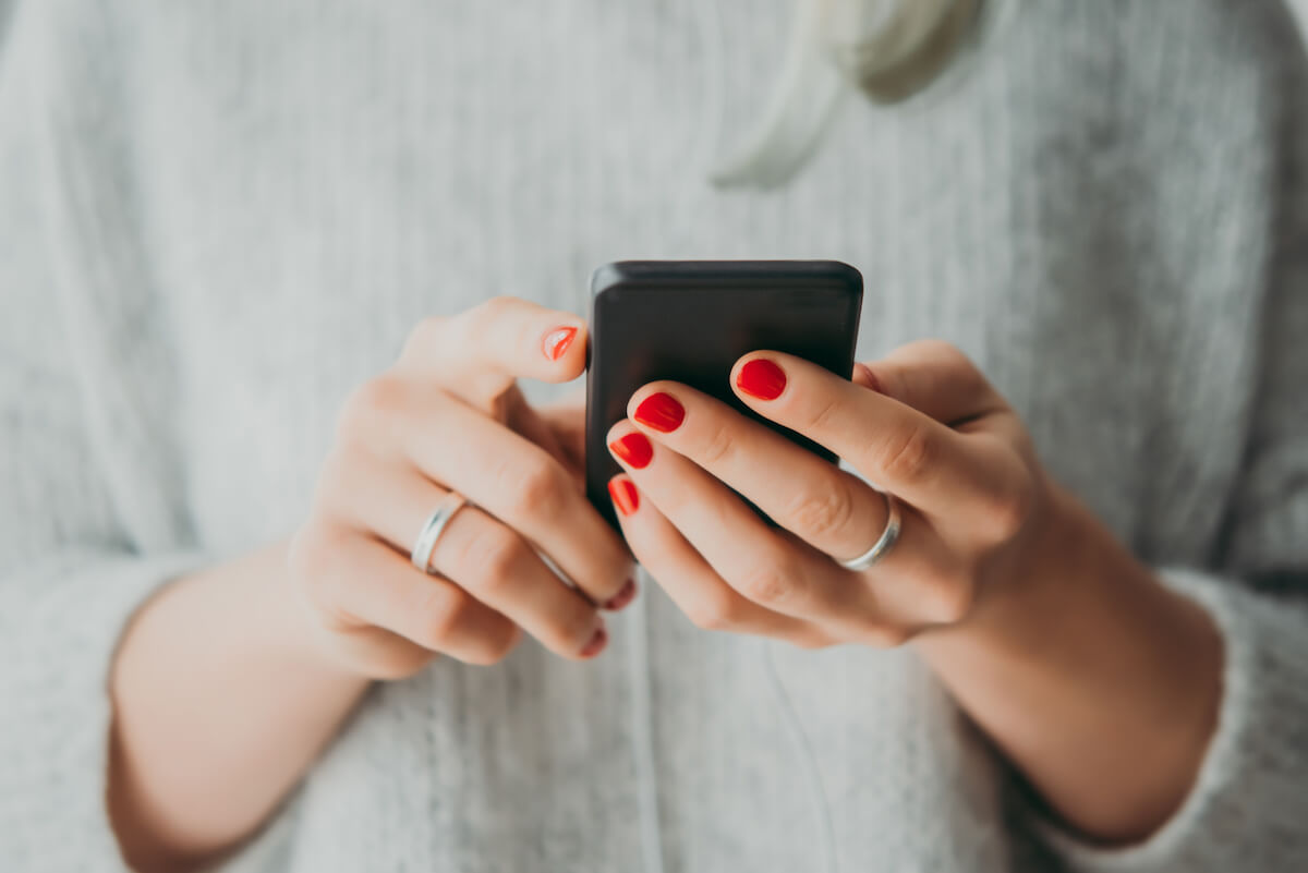 Young woman holding her smartphone