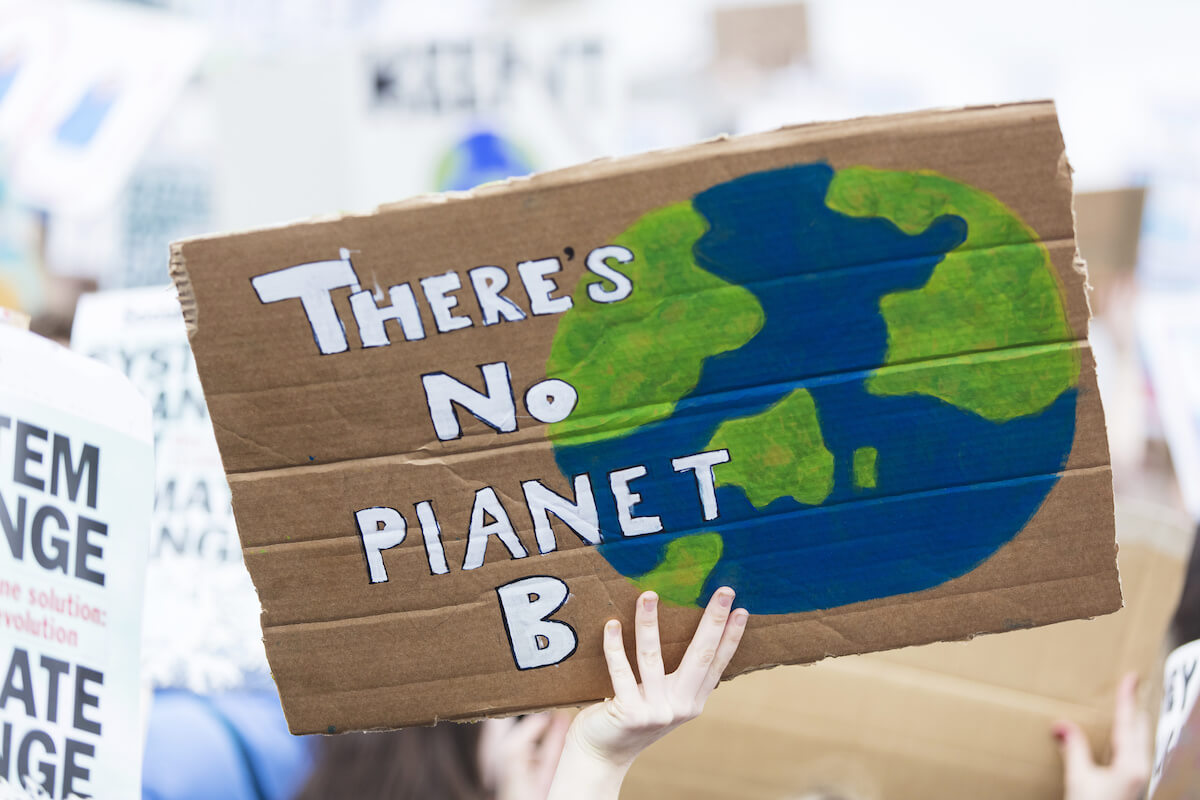 People with banners protest as part of a climate change march