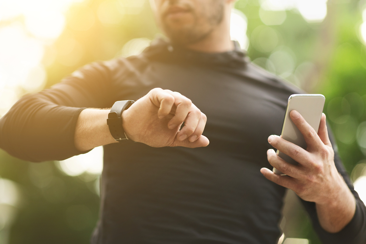 Closeup of man checking workout data on fitness tracker 