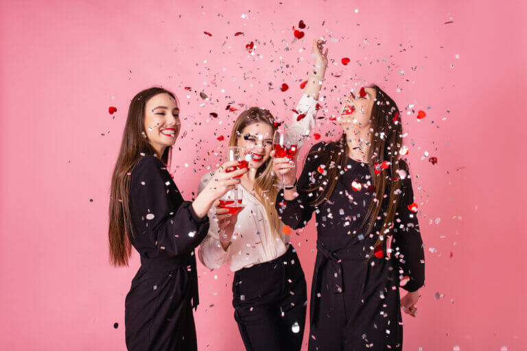 3 girls cheering with confetti and drinks
