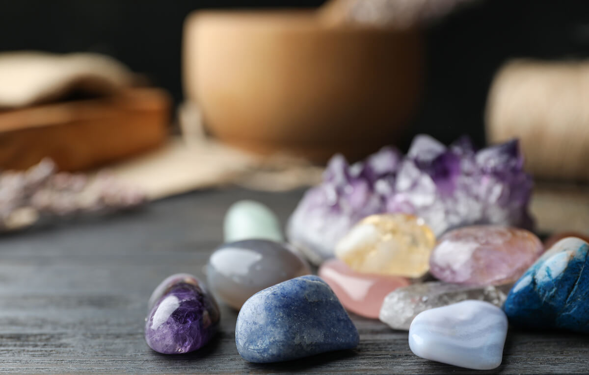 Many different gemstones on black wooden table