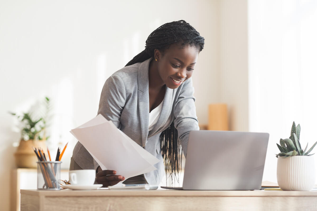 Successful Project. Smiling Afro Business Lady Working With Papers And Laptop In Modern Office, Free Space