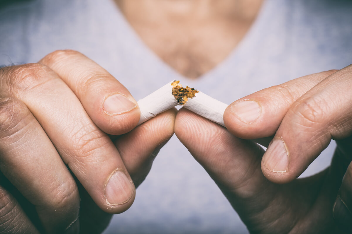 Quitting smoking - male hand crushing cigarette