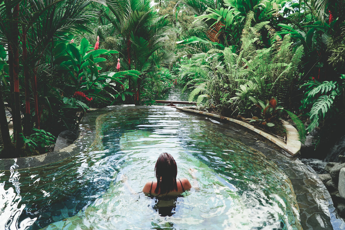 A lady in a swimming pool surrounded by forest in Costa Rica