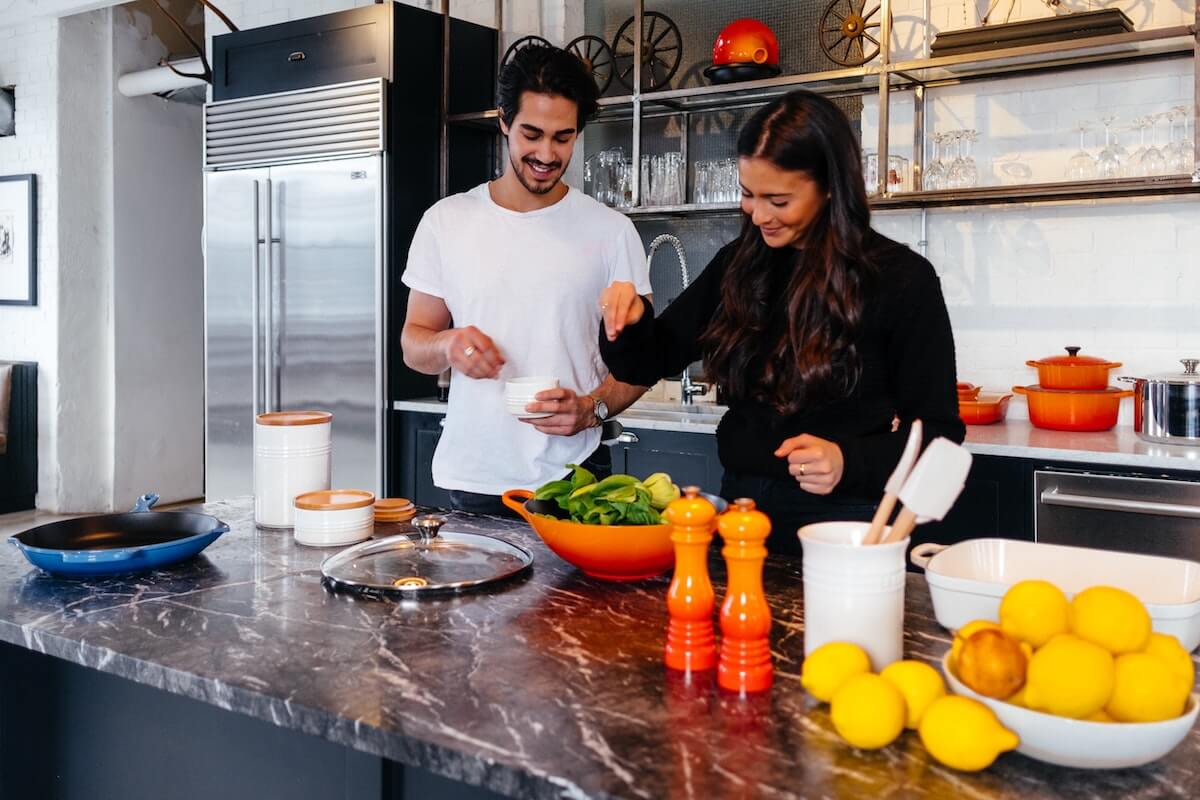 a man and woman cooking in a kitchen