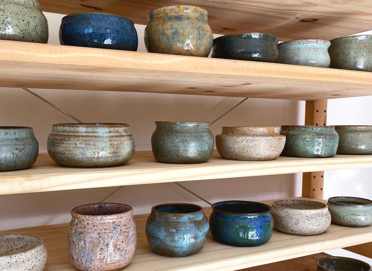 Different pottery pieces on wooden shelves