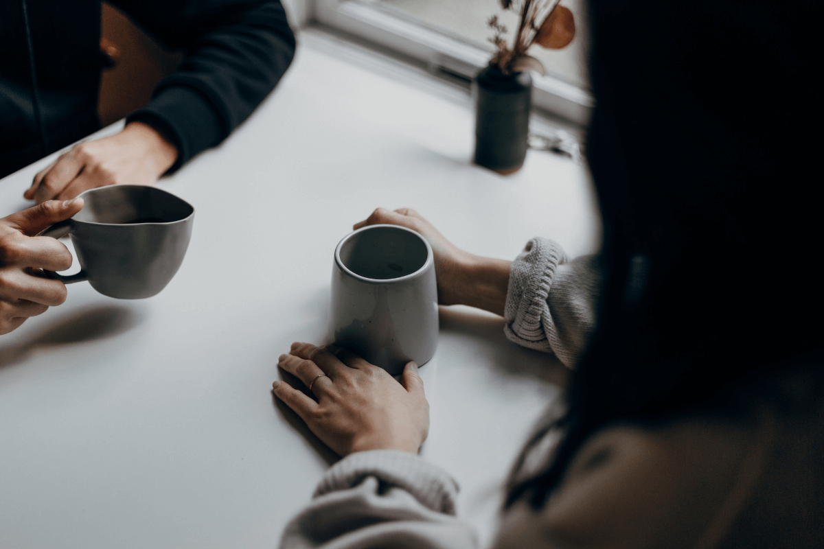 Closeup of two people having coffee (no face shots)