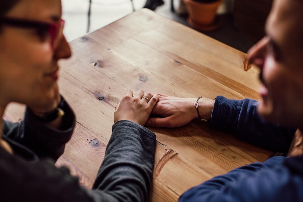 A couple holding hands at a table