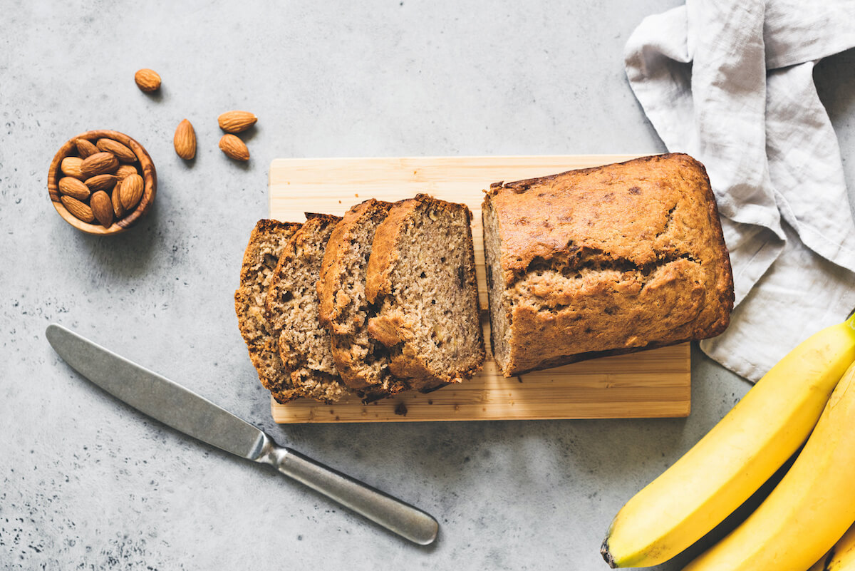 Gluten free paleo banana bread on grey concrete background, table top view.