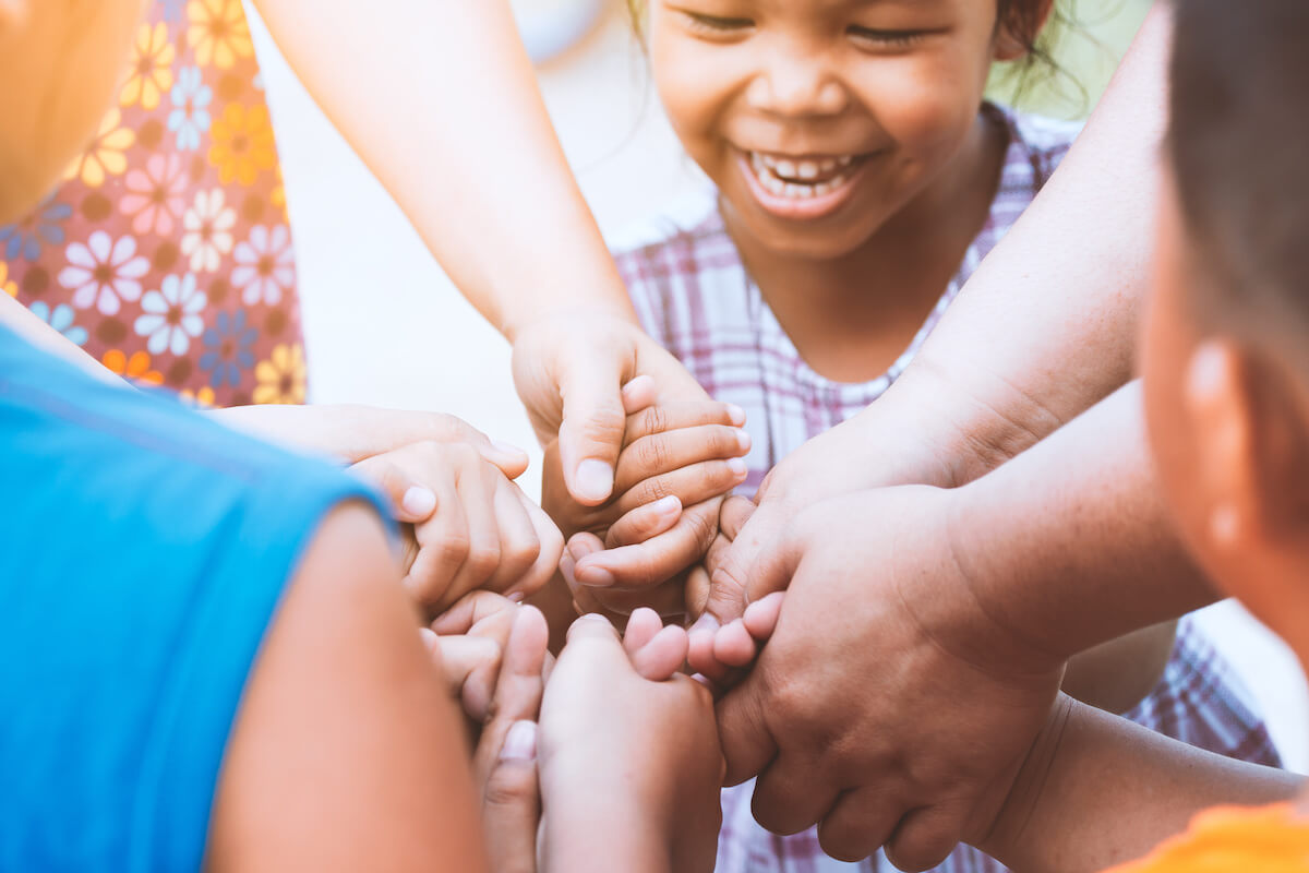 Children and parent holding hands and playing together with unity and teamwork. 

