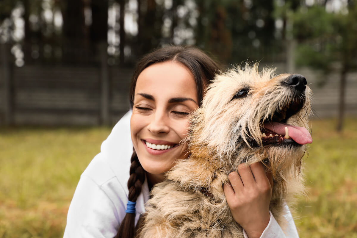 Female volunteer with homeless dog at animal shelter outdoors