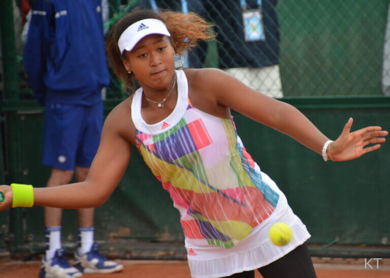 An action shot of Naomi Osaka playing tennis