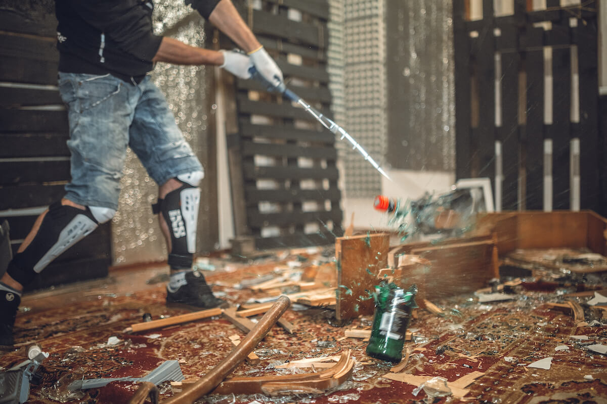 Person in a rage room smashing a glass bottle. 