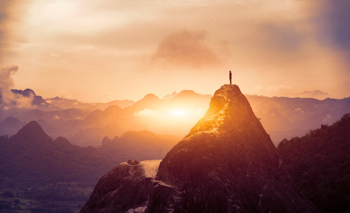 Peak Panoramic view on foggy mountains hills Successfully achieving your goal, Silhouette male on the mountain.