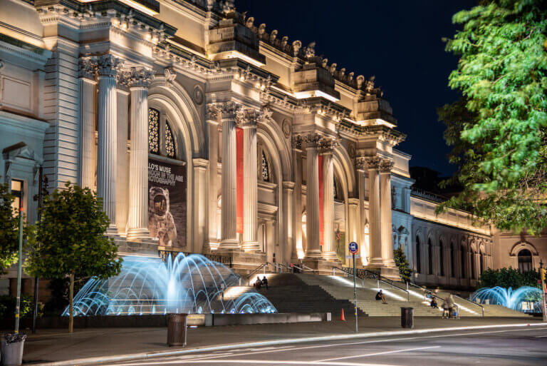 Facade and fountain of the Metropolitan museum of art at night in NYC.