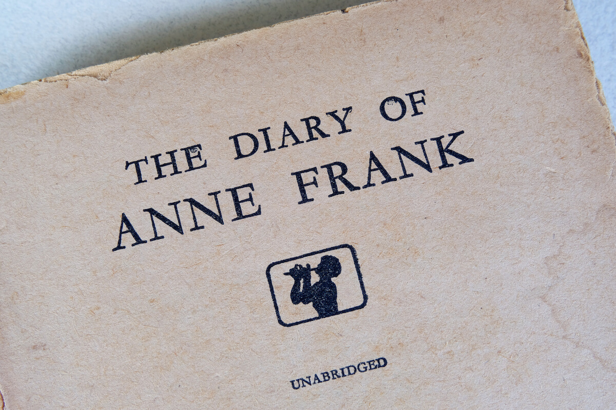 The title 'The Diary of Anne Frank' printed on the first pages of an old English translated book of Anne Frank's diary.