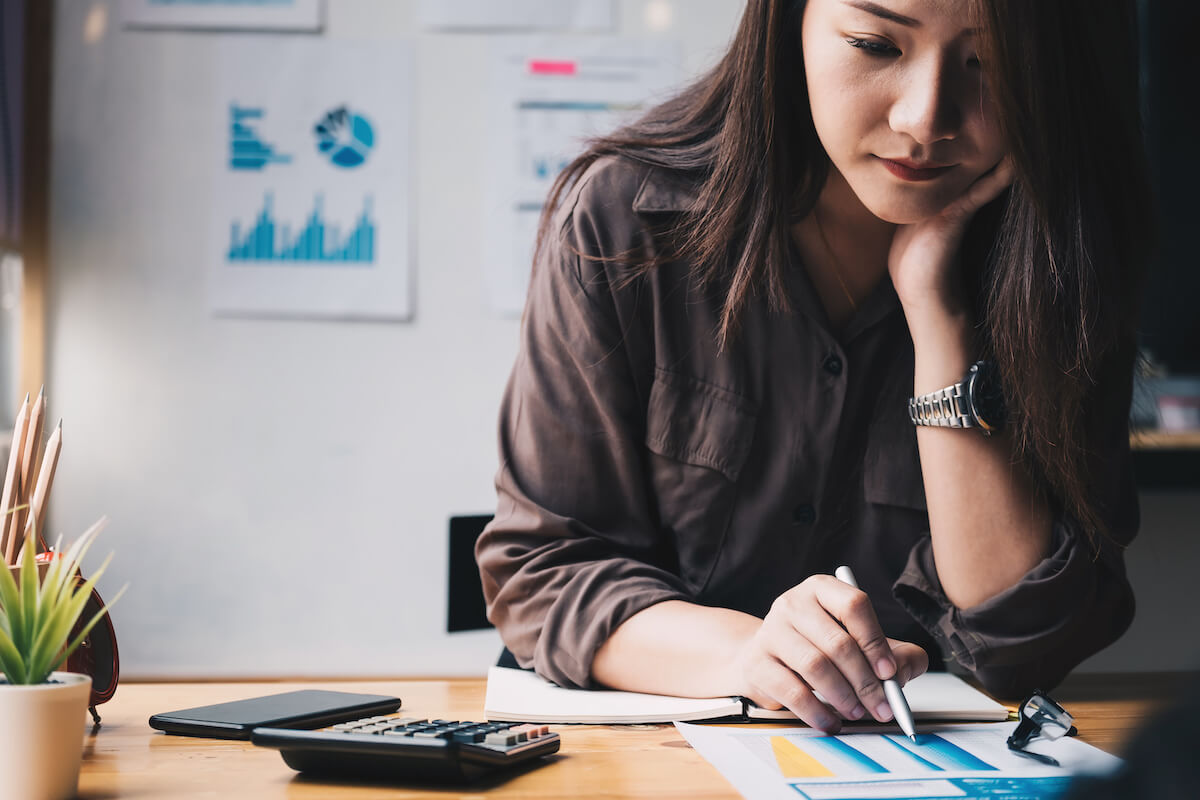 Business woman using calculator for do math finance on wooden desk in office and business working background, tax, accounting, statistics 