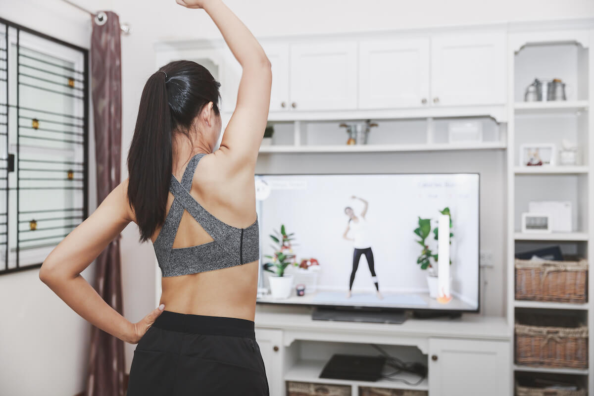 Home healthy exercise concept, Asian fit woman stay home and training online sport workout class on tv at home