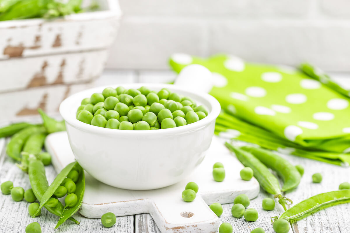 Fresh green peas displayed on wooden table