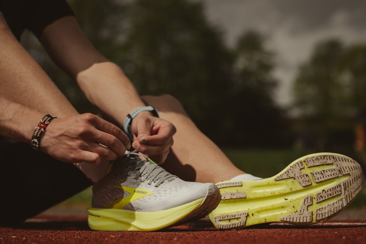 A runner tying up their running shoes.