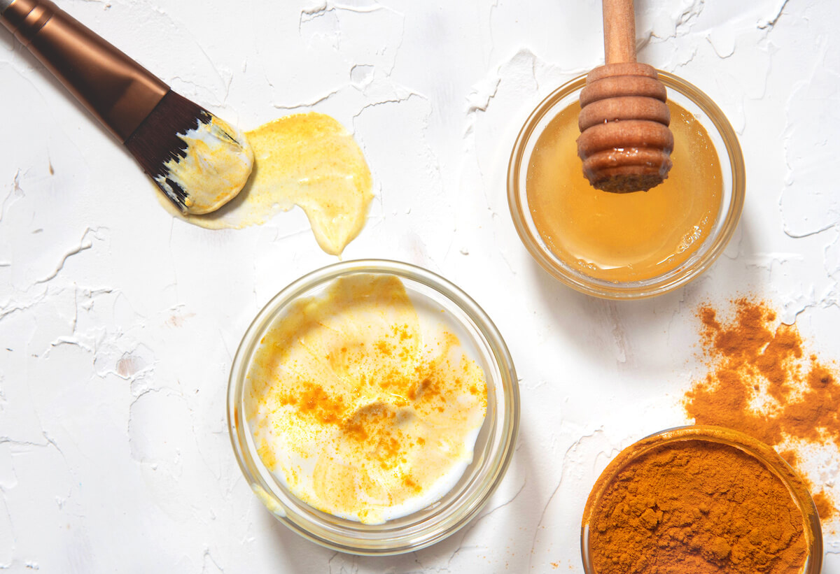 Natural face mask with turmeric powder, honey and yogurt. Natural cosmetics on a white background.