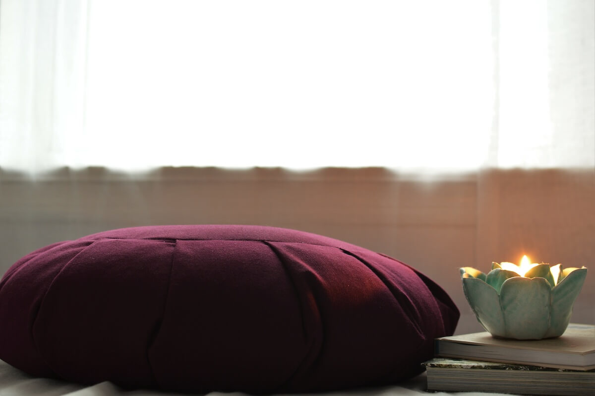 Purple meditation cushion with candle