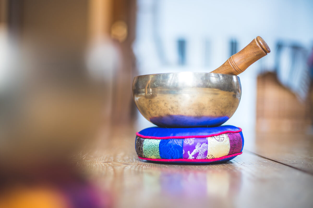 Metal tibetan singing bowl on a rustic wooden floor.