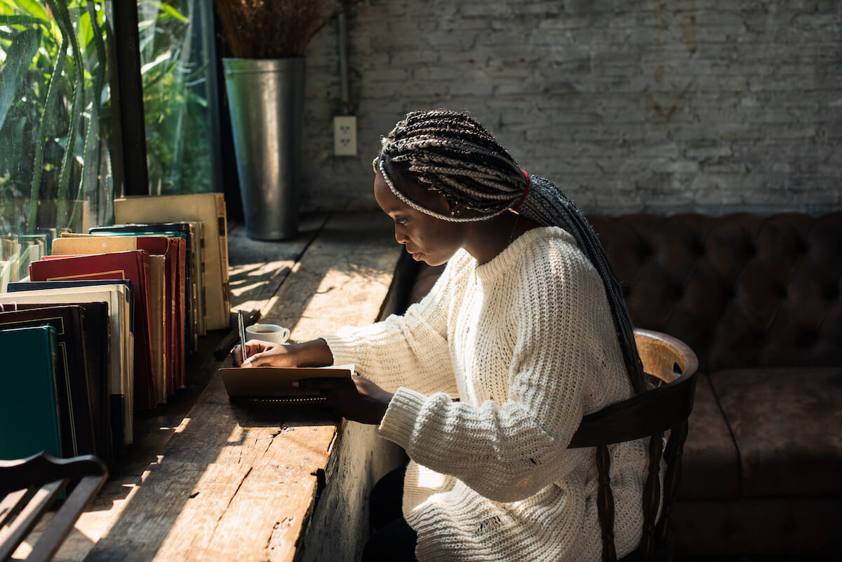 African American female writing in a notebook