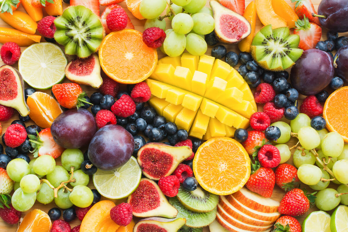 Assortment of healthy raw fruits and berries platter background