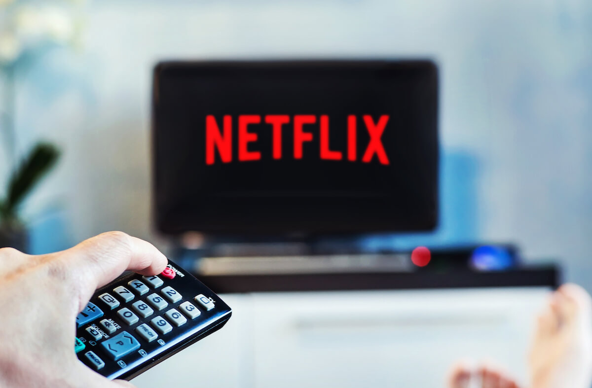 A young man watches Netflix on his TV and at home.