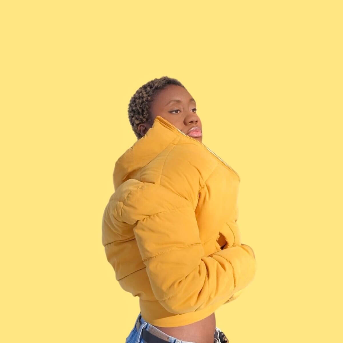 Emerald Osagie wearing a yellow bomber jacket with yellow background.
