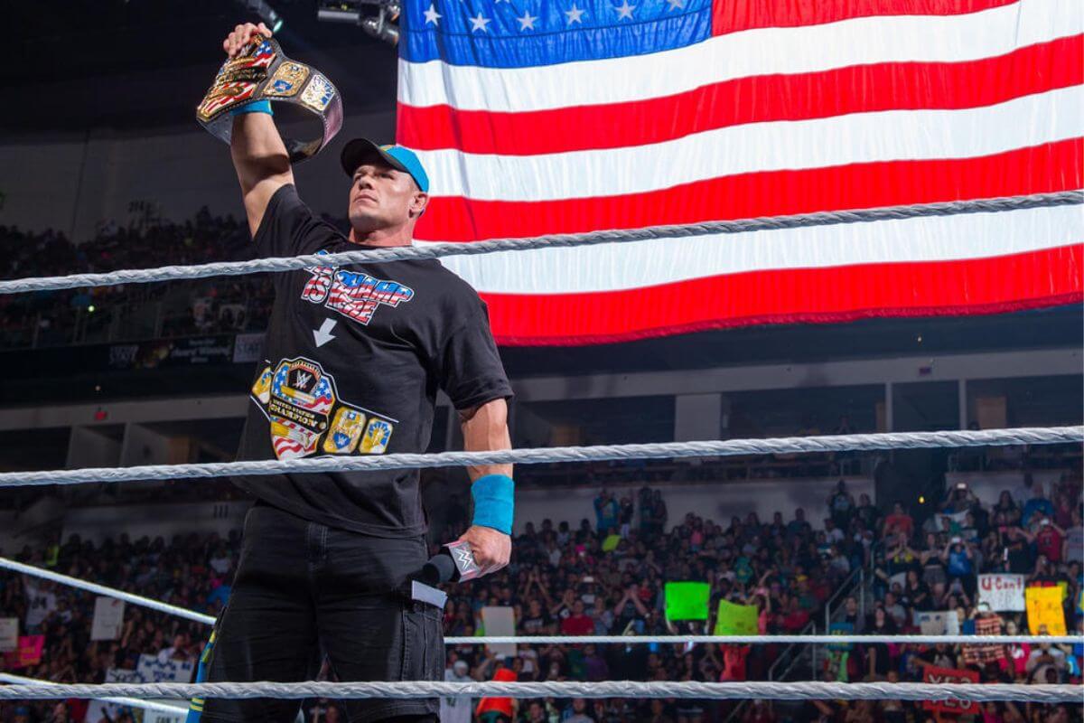 John Cena in a boxing ring holding a champion belt.